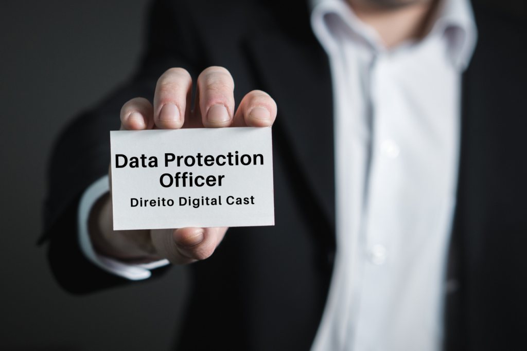 Um homem de terno apresentando um cartão de visita escrito "Data Protection Officer - Direito Digital Cast"